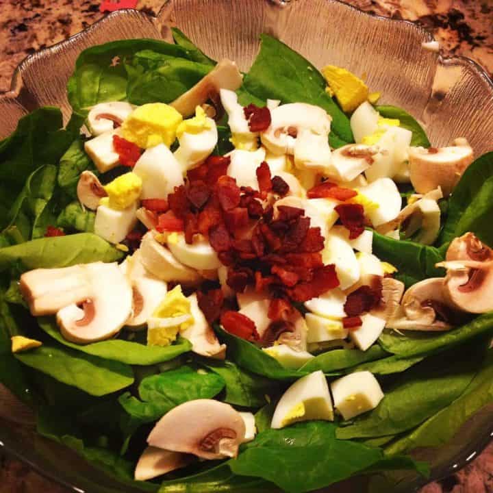 simple spinach salad in a clear bowl