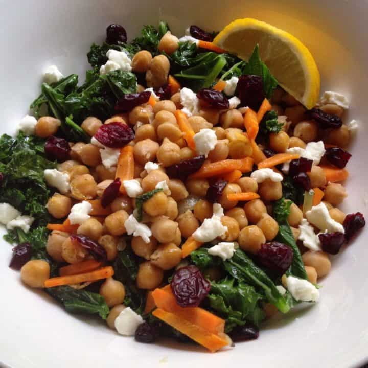 Chickpea and Kale salad with goat cheese on a white plate