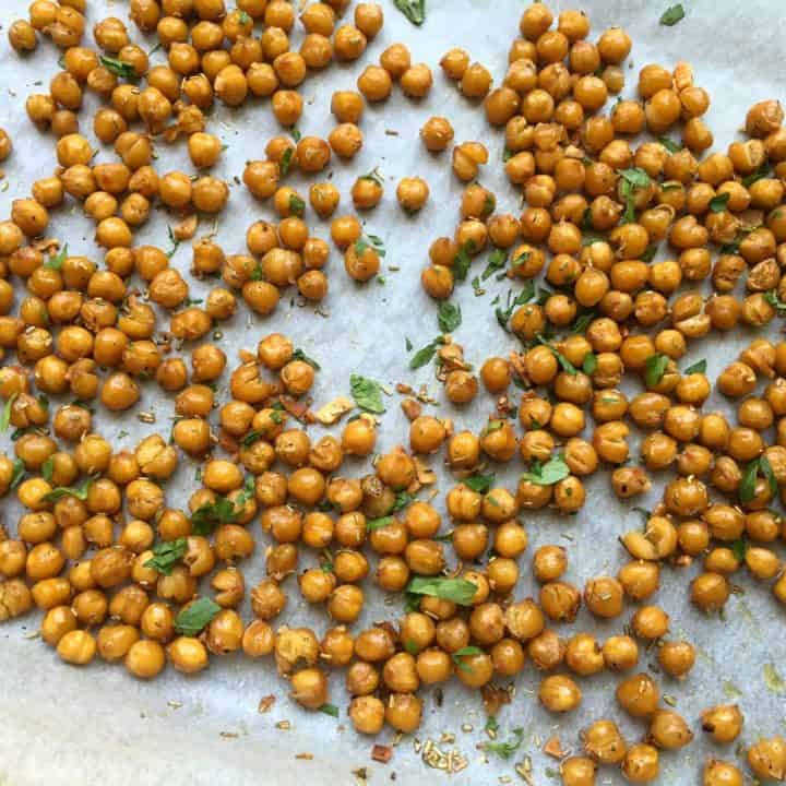 crunchy rosemary roasted chickpeas on a baking sheet, topped with parsley