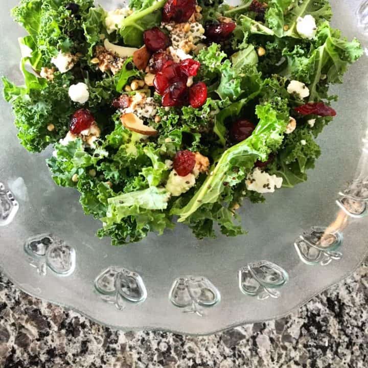 Kale Salad in a plastic bowl, on top of a marble countertop