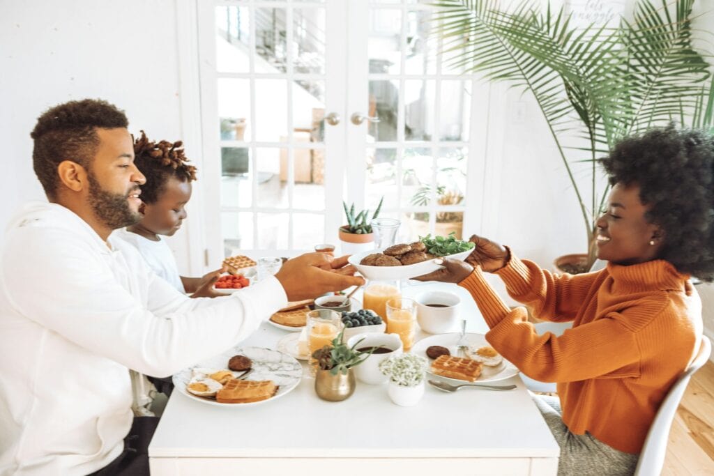 Family sharing a meal at the dining table with healthy food options.