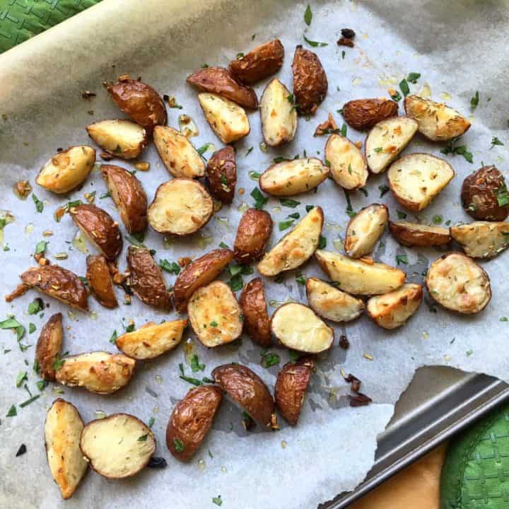 roasted red skinned potatoes with garlic and rosemary on a baking platter