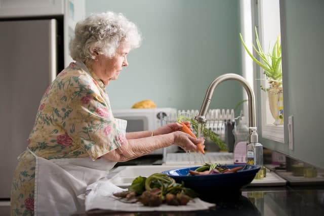 older adult washing veggies