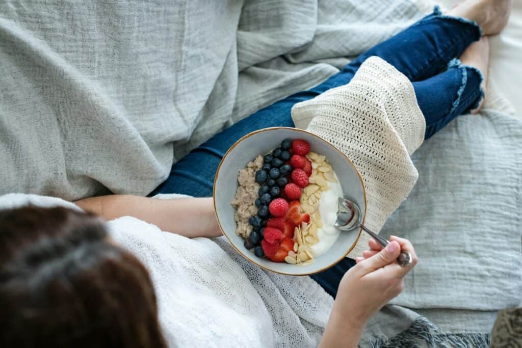 Healthy summer berries and oatmeal bowl with raspberries, blueberries, and cream.